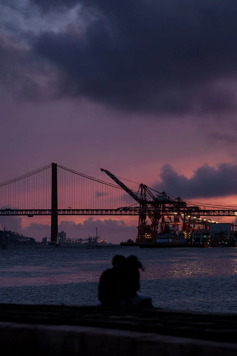 Couple at dusk before the Ponte 25 de Abril